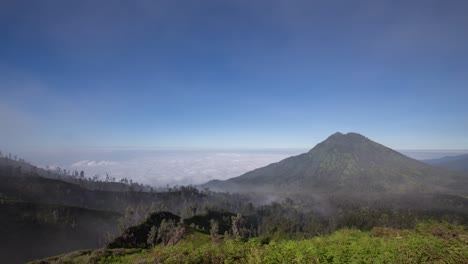 niebla moviéndose sobre el paisaje volcánico y nubes rodando debajo en monut ijen, java oriental