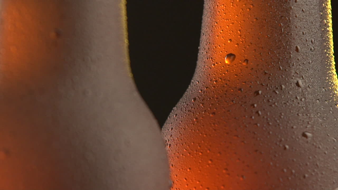 Two beer bottle rotating on black background