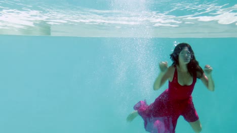 Brunette-in-evening-gown-diving-into-swimming-pool