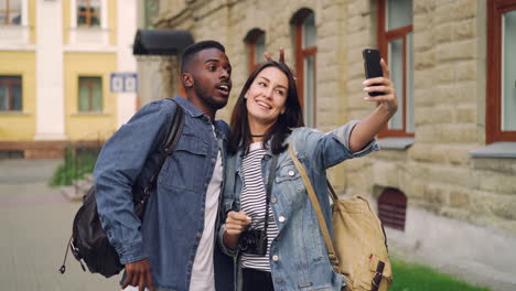 happy couple taking selfie in city street