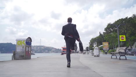 Man-in-suit-is-running-by-the-sea.-Slow-motion.