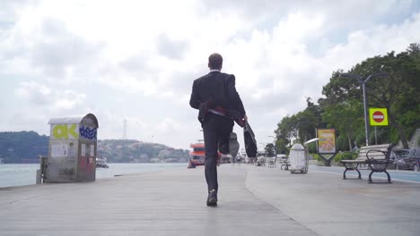 man in suit is running by the sea. slow motion.