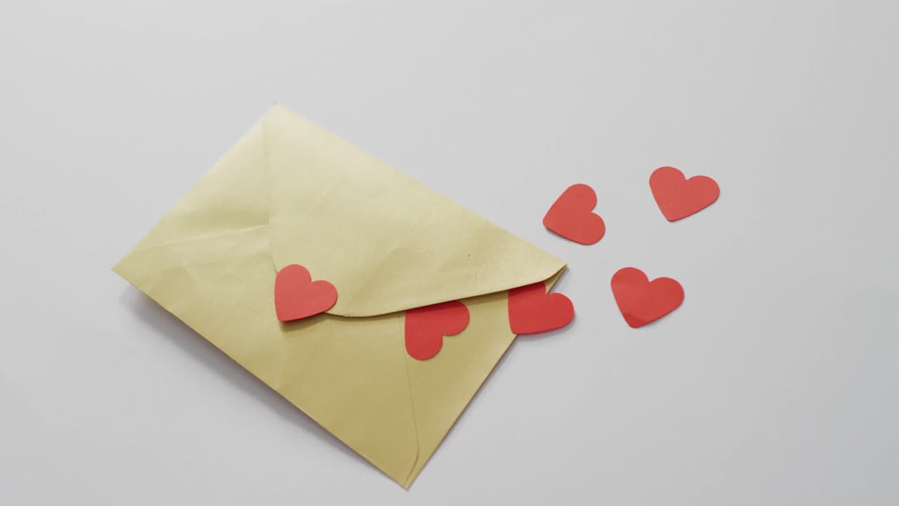 Paper hearts and envelope on pink background at valentine's day