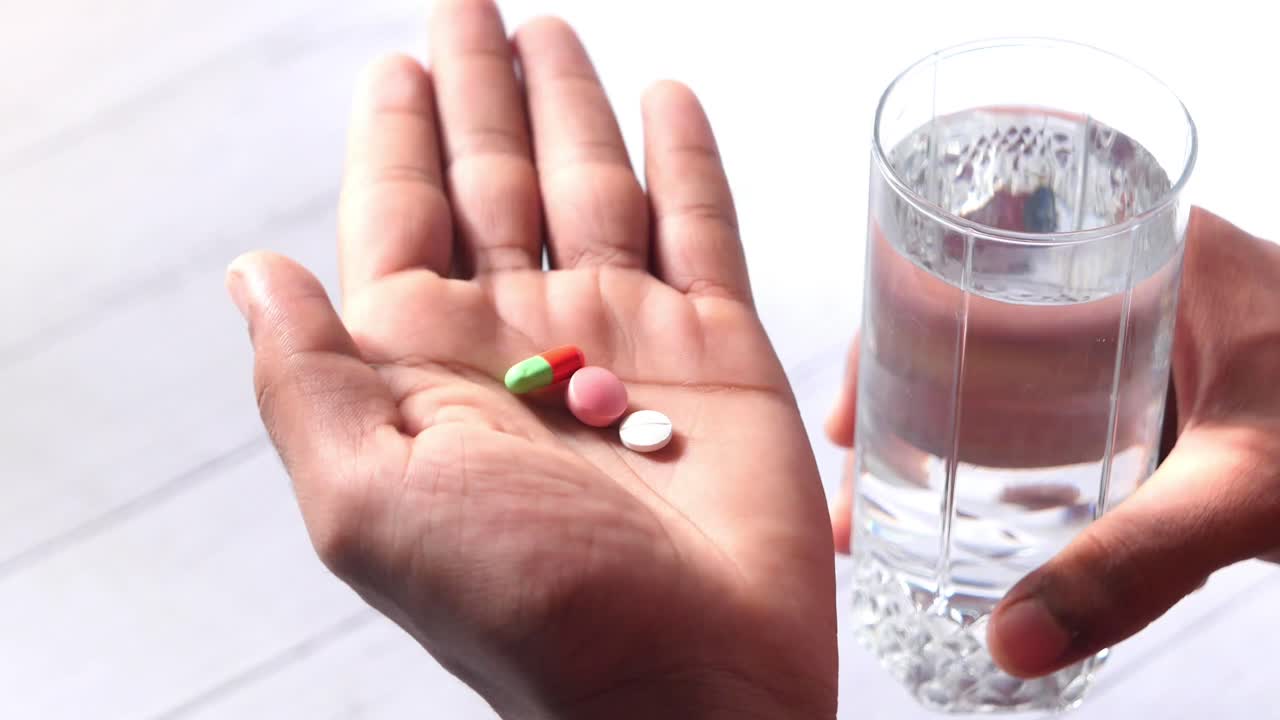 persona que toma pastillas con agua