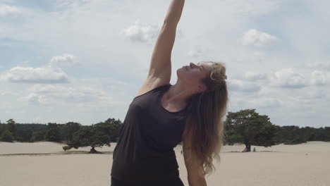 mujer atractiva alcanzando el cielo mientras hace ejercicio de yoga