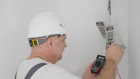 A-male-electrician-installs-transformers-for-illumination-in-a-smart-home-system.-Installation-Check-Lighting