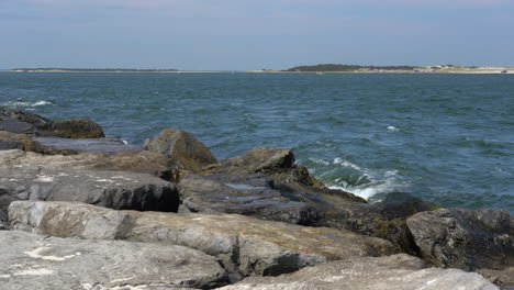 the ocean waves breaking in the rock jetty