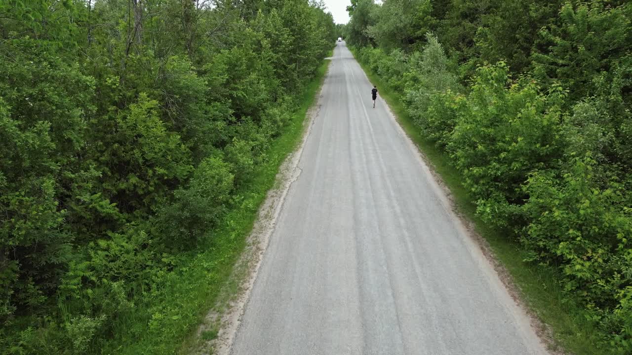 시골 도로 에서 혼자 달리는 사람 의 공중 전망