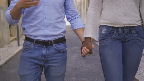 una foto recortada de una pareja multirracial que se da la mano.