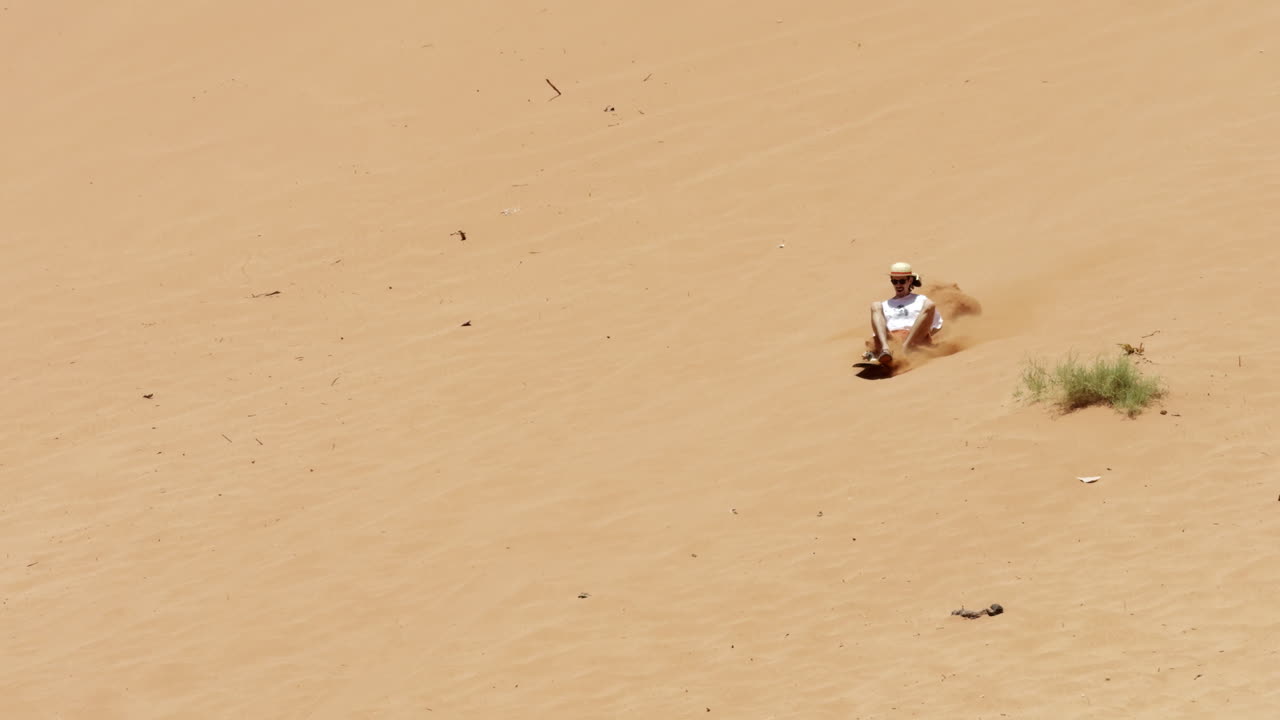 사막 의 모래 언덕 을 내려가는 사람