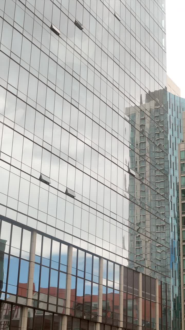 Panorâmica ascendente revelando edifícios modernos da cidade e fachadas de vidro