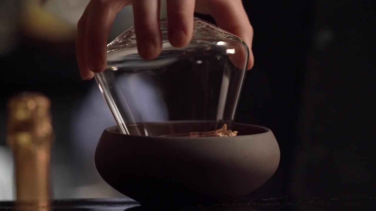 A bartender is garnishing the cocktail glass creating crusta around the rim of the crystal glassware.