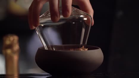 a bartender is garnishing the cocktail glass creating crusta around the rim of the crystal glassware.