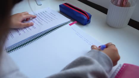 joven escribiendo en un cuaderno en un escritorio de estudio