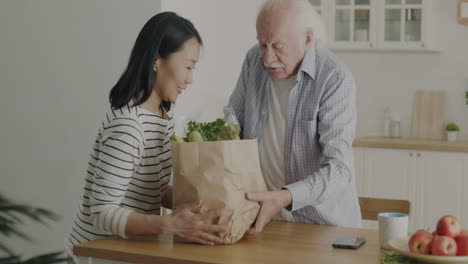helping hand: daughter assisting elderly father with groceries
