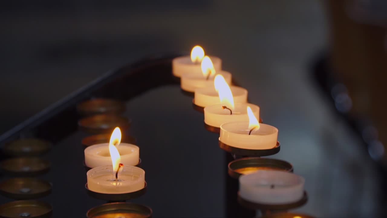 Lit tealight candles flicker in Salisbury Cathedral, evoking reflection, prayer, and spiritual reverence in a historical English church interior.
