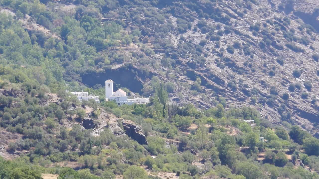 Zoom in on the Church of Our Lady of the Rosary in Bubión, a 16th-17th century temple with a Mudéjar tower. Located in the Poqueira Ravine, in the Alpujarra region of Granada