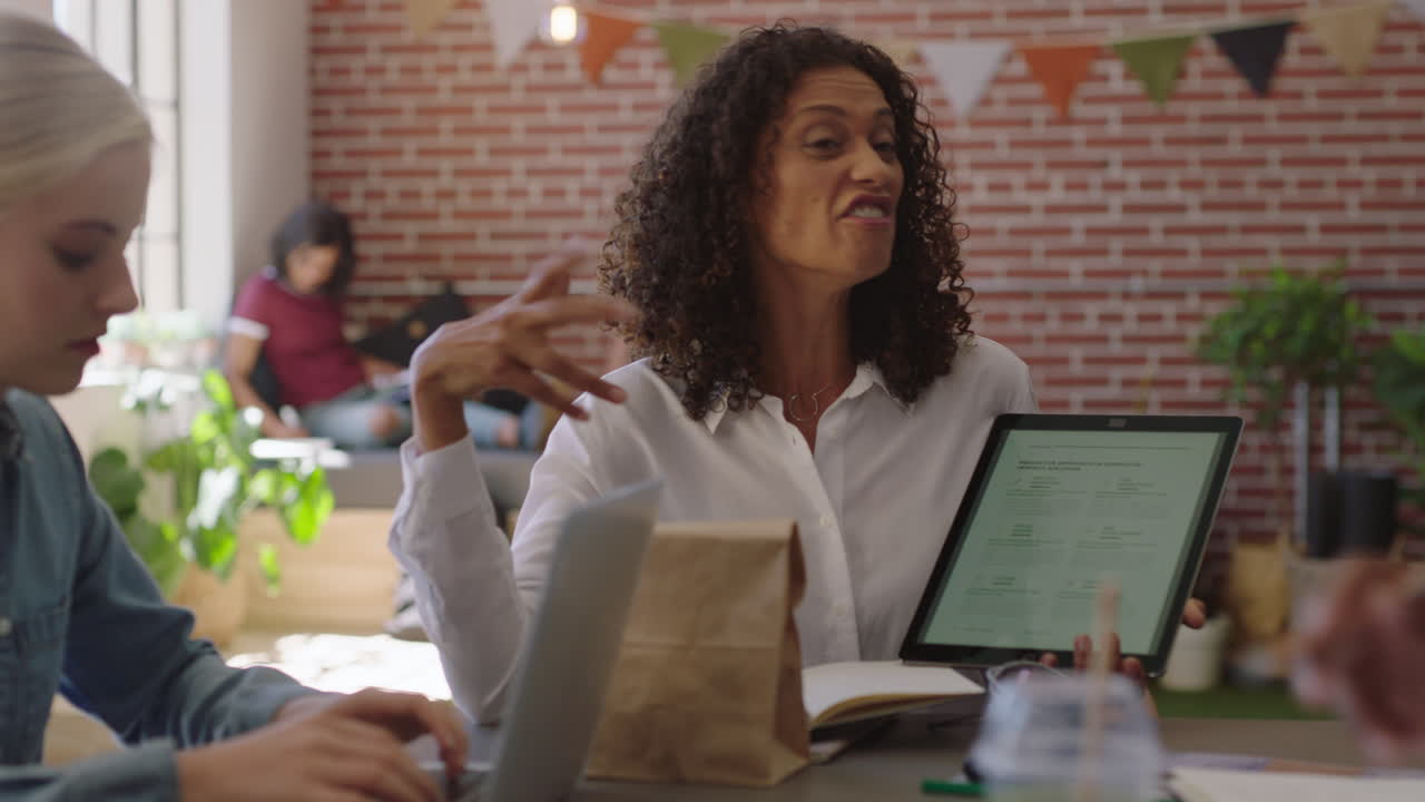 mujeres de negocios multiétnicas se reúnen líder de equipo de lluvia de ideas compartiendo ideas creativas para un proyecto de puesta en marcha utilizando tecnología de tableta en el lugar de trabajo de la oficina moderna presentación