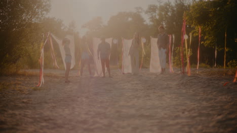 young friends standing side by side at beach