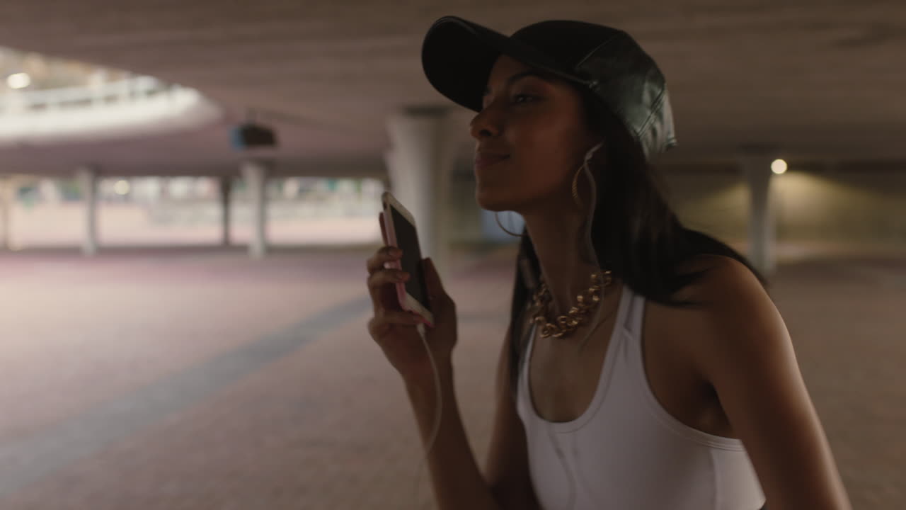 bailarina de calle feliz con auriculares disfrutando de escuchar música hip hop usando un teléfono inteligente realizando movimientos de baile de estilo libre en la ciudad