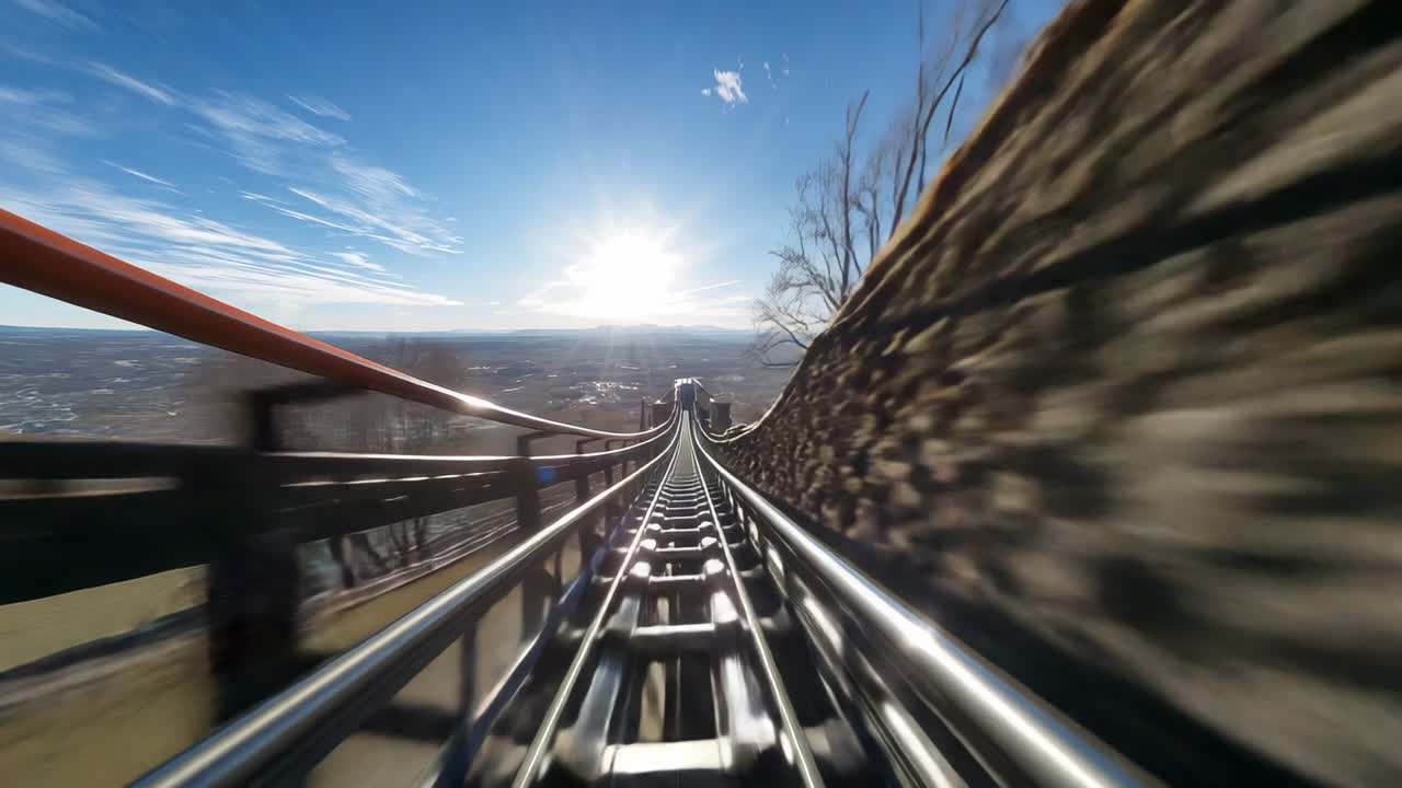 Pulling alpine coaster car by gravity into steep drop on ridge, with blurred rails, fence, wall