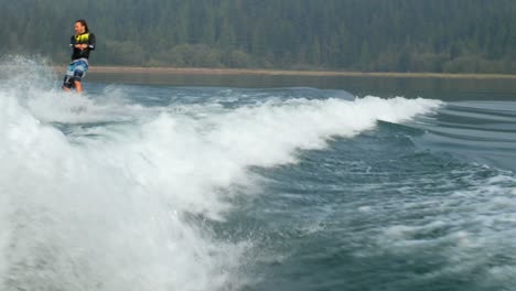 Vorderansicht-Eines-Kaukasischen-Jungen-Mannes,-Der-Tricks-Auf-Dem-Wakeboard-Im-Stadtfluss-Macht,-4k