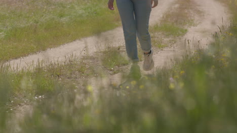 a woman walks peacefully along a quiet rural road surrounded by natural scenery, evoking solitude and connection with the outdoors