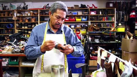 zapatero aplicando pegamento en el zapato