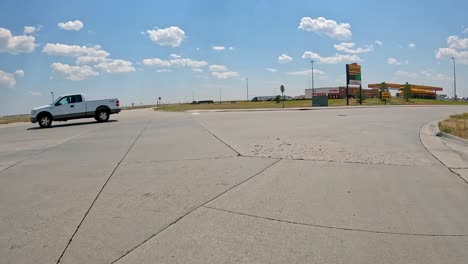 pov - driving on the frontage road to pull into the truck entrances for love's travel stop; preparing to get diesel for over-highway truck; concepts of logistics, road trip and highway transportation
