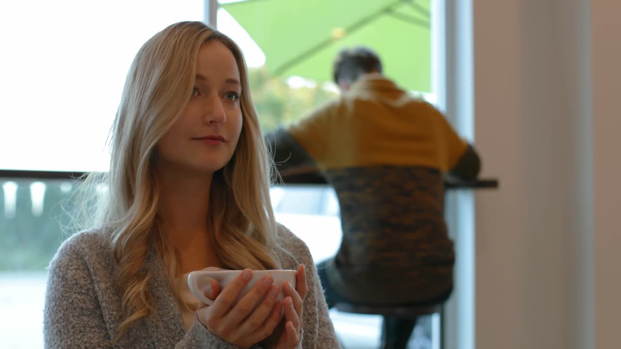 Bella donna che prende un caffè al bar 4k