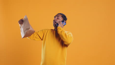 man packing food in thermal backpack, fulfilling clients orders, studio backdrop