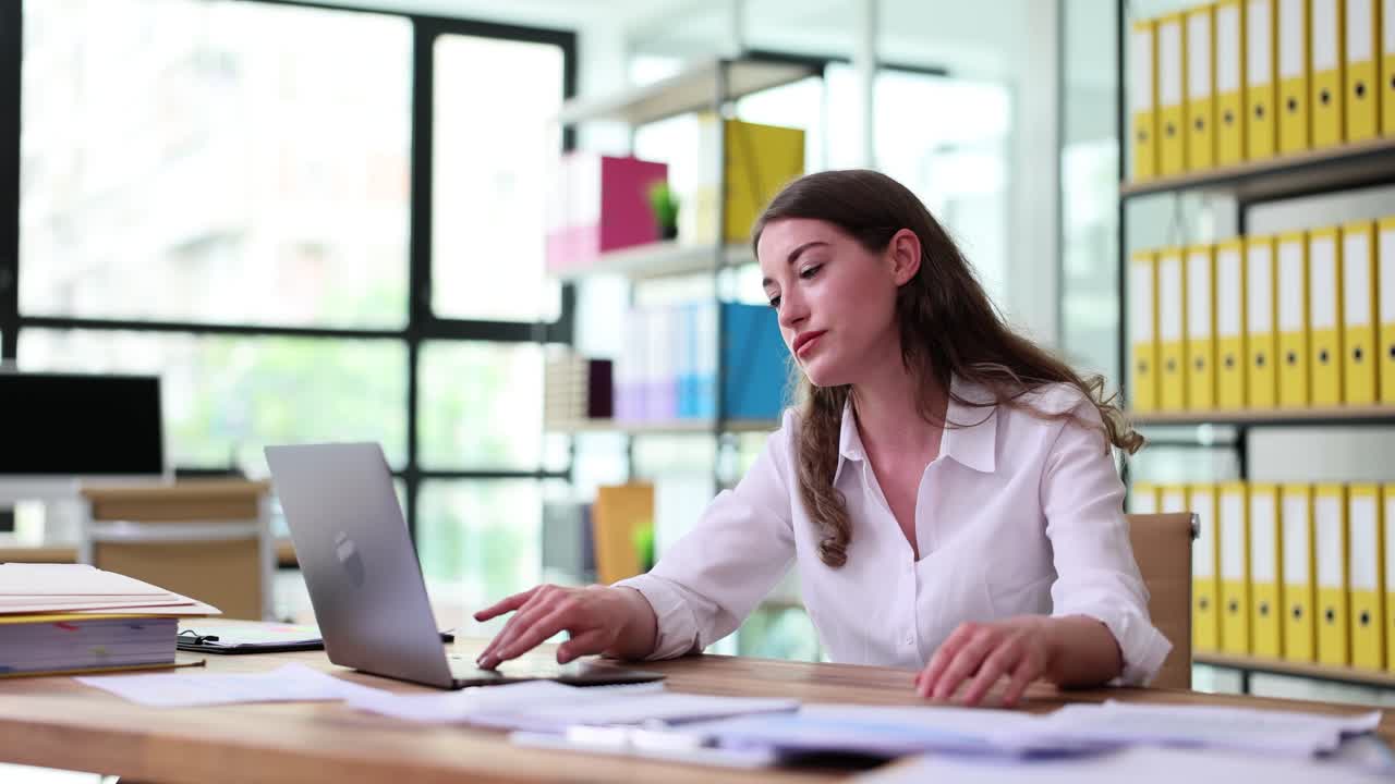 Tired Businesswoman Yawning While Working on Laptop in Office