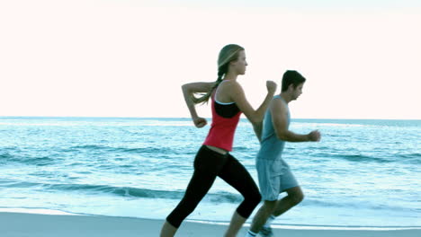 dos amigos corriendo por la playa