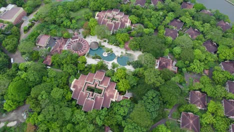 Un-Dron-Elevado-Desde-Arriba-Hacia-Abajo-Sobre-Un-Resort-Y-Un-Campo-De-Golf,-Con-Edificios-Y-Tejados-únicos-De-Estilo-Centroamericano,-Rodeado-De-Una-Densa-Jungla,-En-El-Norte-De-Costa-Rica