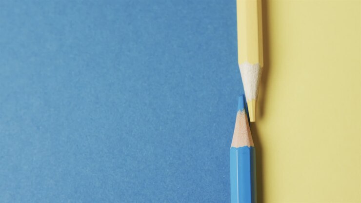 Close up of blue and yellow pencils with copy space on blue and yellow background