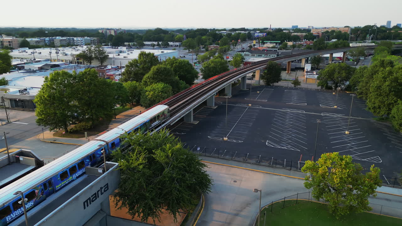 vista aérea del tren de metro que sale de la estación y pasa por una línea elevada a través de los suburbios