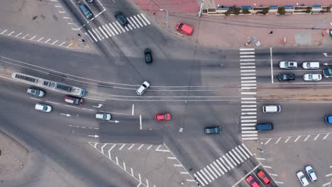 aerial view from a drone of a road intersection in the city with cars, tram and pedestrians. movement of city transport on the street. road with markings, signs and traffic lights