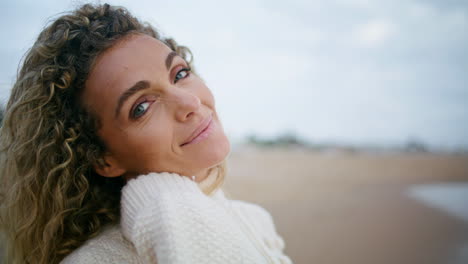 retrato romántico mujer mirando cámara playa. hermosa mujer rizada descanso océano