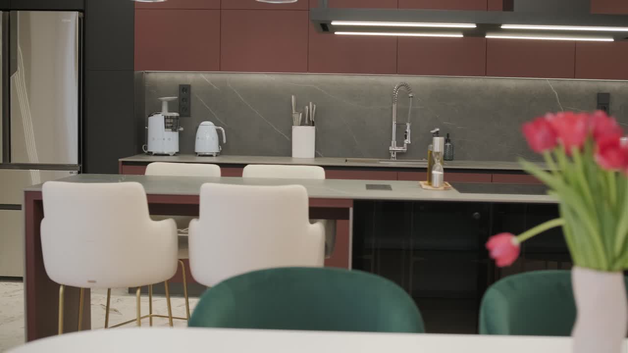 Stylish modern kitchen with red cabinets, a marble backsplash, and state-of-the-art appliances