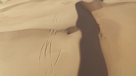 drone shot of car tracks running through the desert