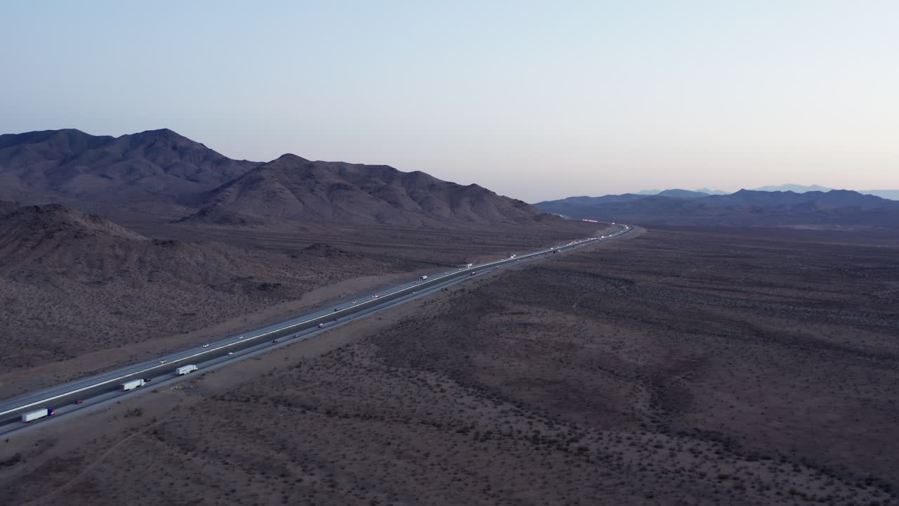 캘리포니아 사막 풍경을 가로지르는 주간 고속도로에서 운전하는 트럭의 조감도