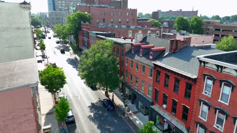 small city street lined with brick apartment buildings and small businesses