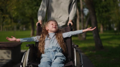 toothless girl sits in wheelchair spreading hands to sides