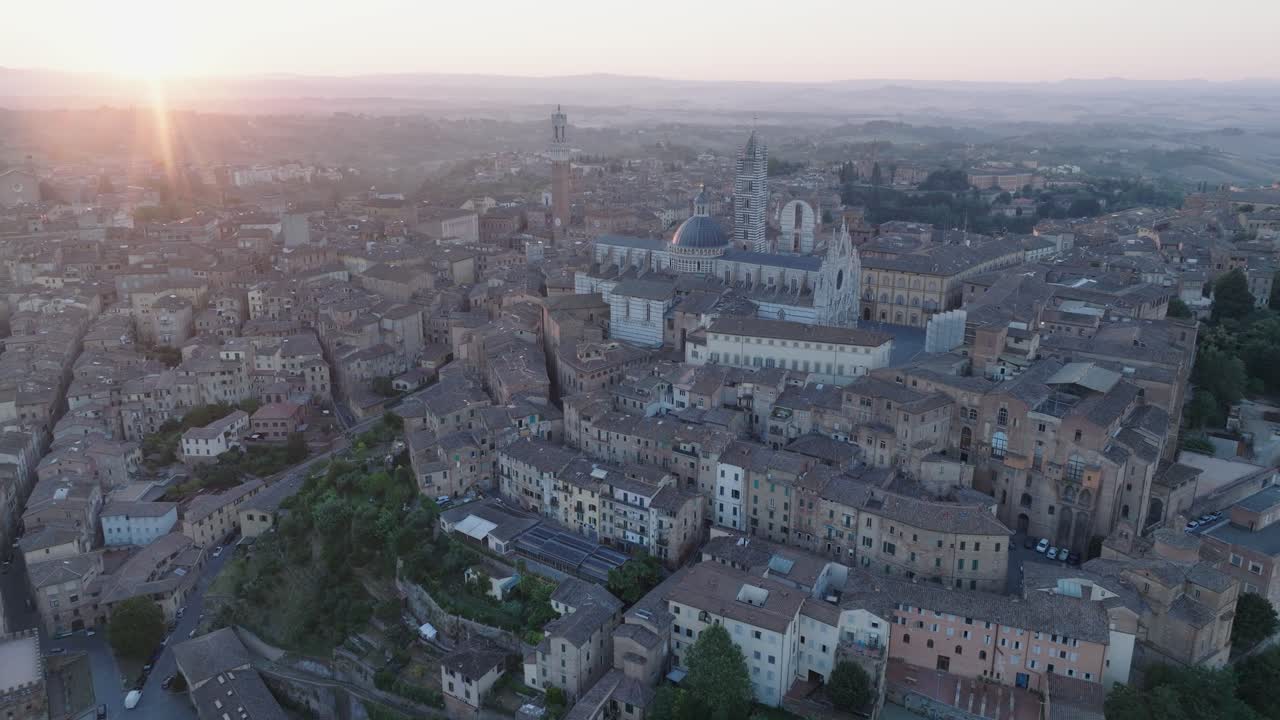 vista aérea de siena, toscana, italia al amanecer con el duomo de sienta, la torre del mangia, la llamarada solar y la ciudad medieval en 4k