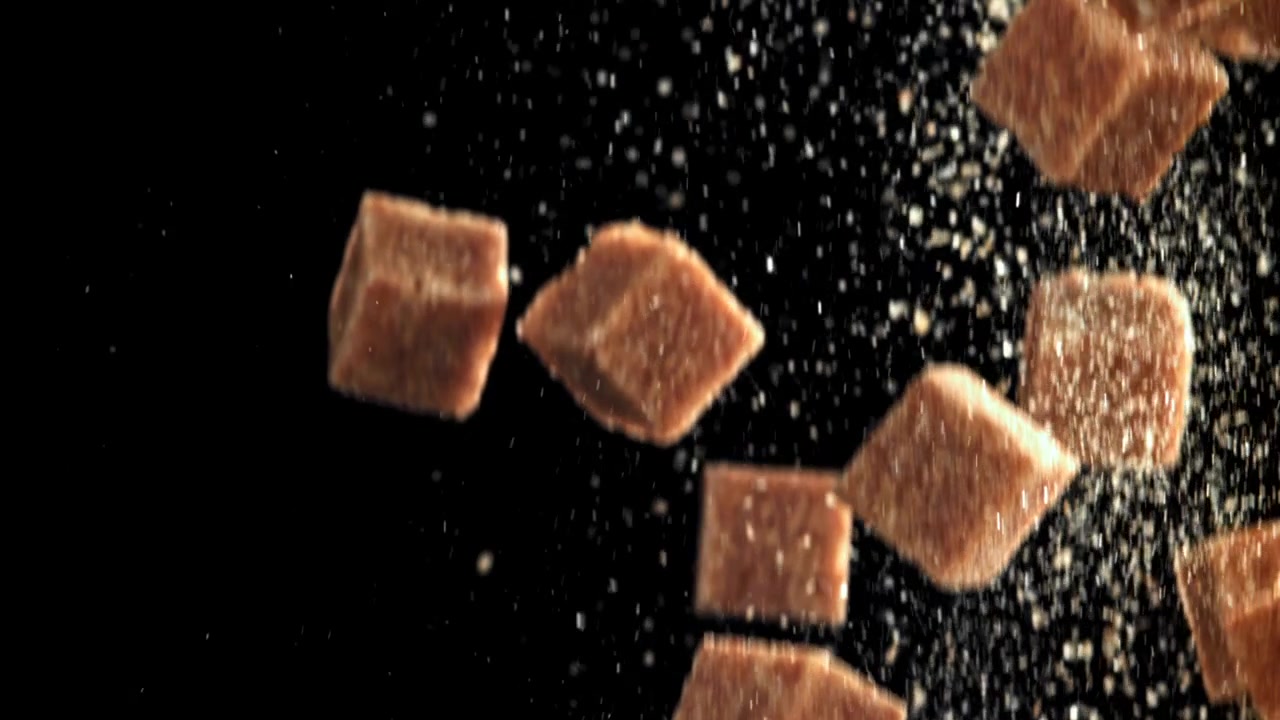 Brown Sugar Cubes Falling in Slow Motion on Black Background