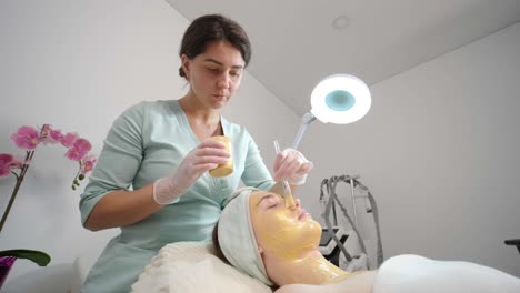 professional face care procedures in the modern cosmetology clinic. beautician is doing face treatment procedures - purification, mask, peeling, carboxytherapy