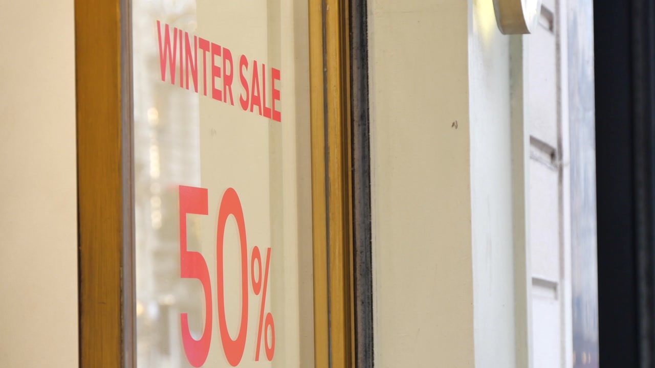 Close-up of a Winter Sale 50% Discount Sign on a Store Window