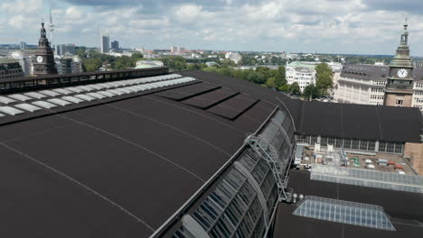 Forwards-fly-above-main-trains-station-building.-Revealing-heavy-road-traffic-on-bridge-and-multiple-trains-going-on-tracks.-Free-and-Hanseatic-City-of-Hamburg,-Germany