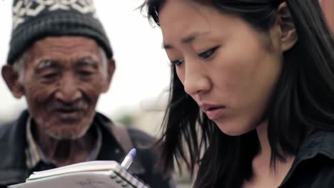 a thoughtful encounter: a young woman captures memories while an elderly man observes with a smile in a moment of connection and reflection