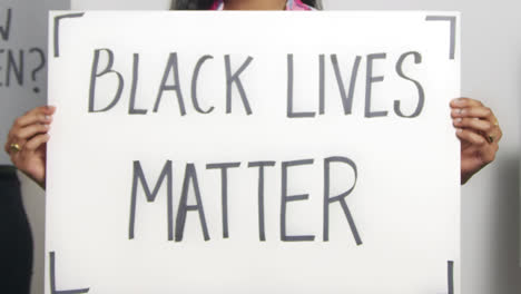 cerca de una mujer sosteniendo un cartel de black lives matter